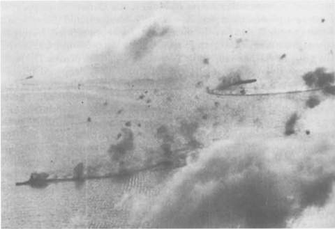 Clouds and antiaircraft bursts darken the sky as smoke wreathes either the Kongo or Haruna. The carrier in the right background is the Chiyoda. (National Archives)