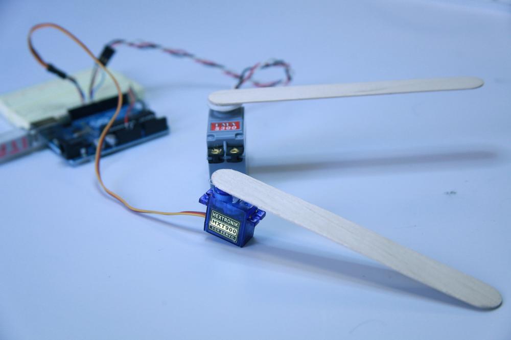 Our servos with popsicle sticks attached. Make sure you attach your popsicle sticks facing the right direction to achieve the correct range of motion.