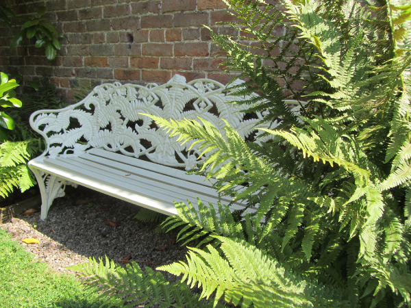 Image of a cast iron bench with fern motif along the back arms and legs, Berrington Hall, Herefordshire. 