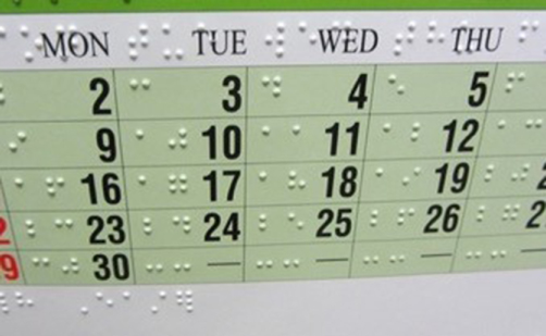 Image of a typical Braille calendar, showing raised braille dots alongside large font numbers and text.