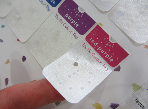 Image of clothes tags, with raised dots for identifying and coordinating the coloured garments. 