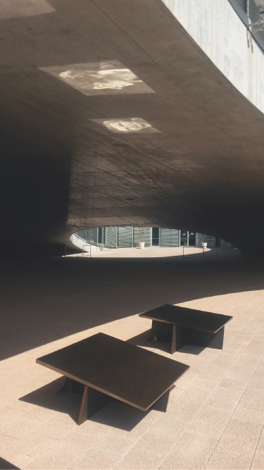 Photograph showing solid installation (EPFL).  Reflections of Marie Curie and Alan Turing can be seen on the underside of the roof of the building.  