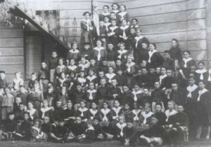 Nejmladší žactvo na hromadné fotografii na nouzovém schodišti za slánskou sokolovnou v roce 1911 - Foto: Slánské listy