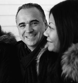 A smiling man wearing a scarf