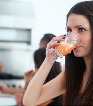 A woman drinking a glass of juice