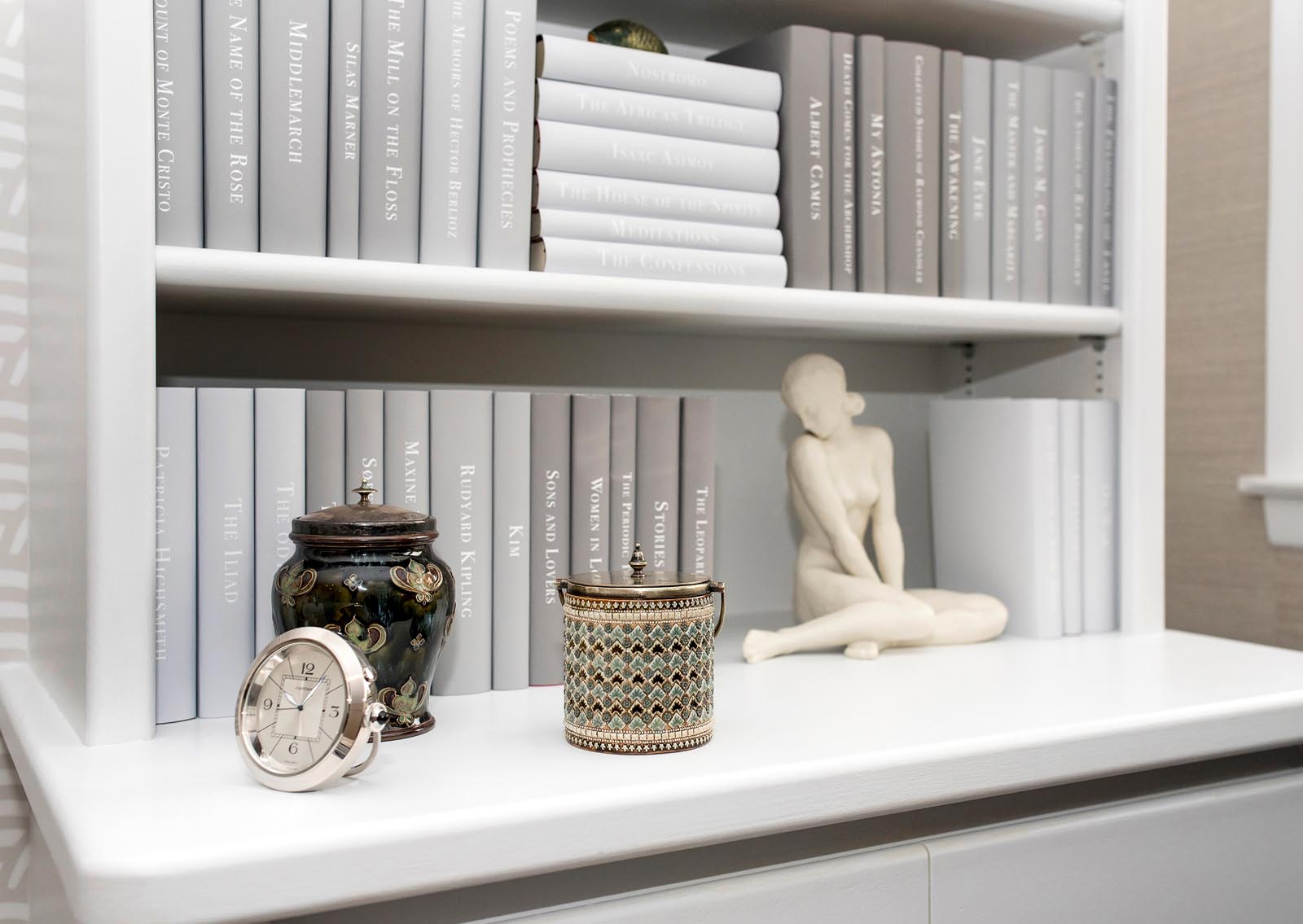 Photo of some shelved with books jacketed in gray tones.