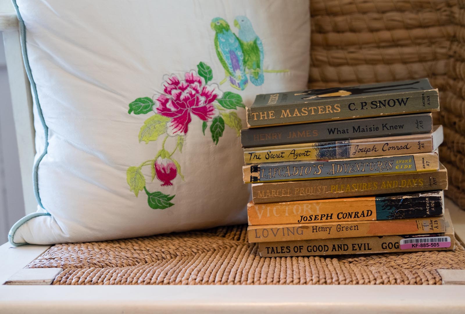 Photo of a group of older paperbacks on a chair seat.