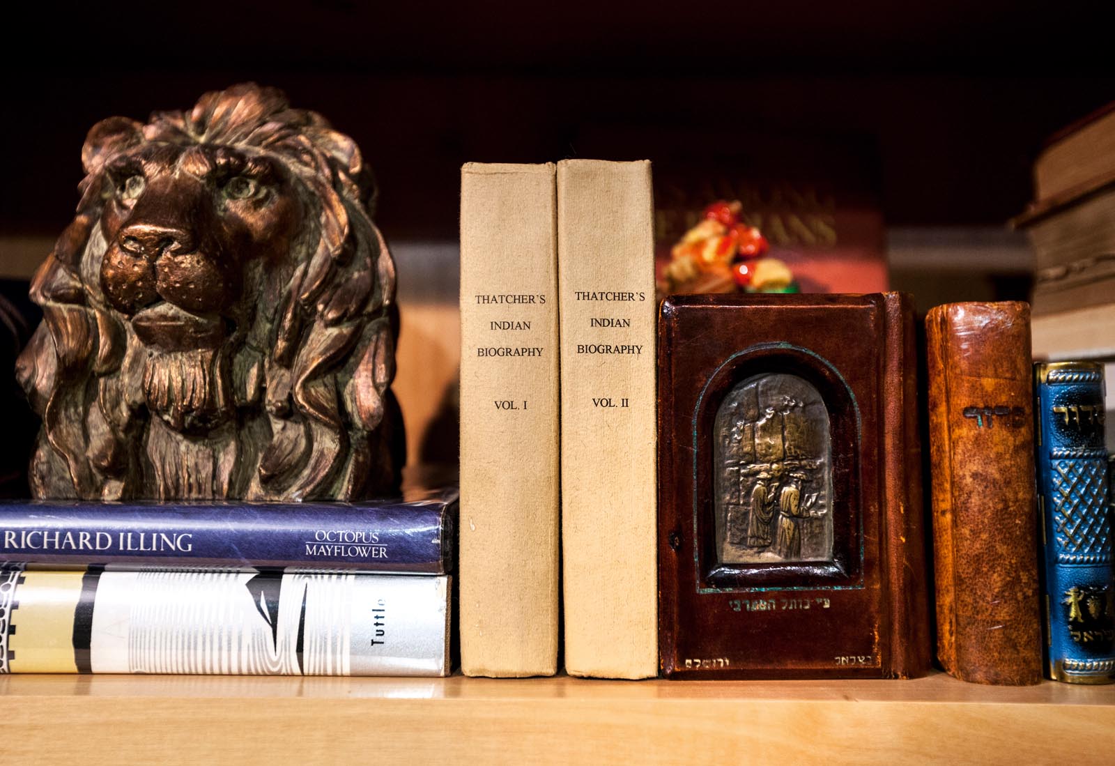 Photo of Hebrew prayer books among others, together with a carved lion head.