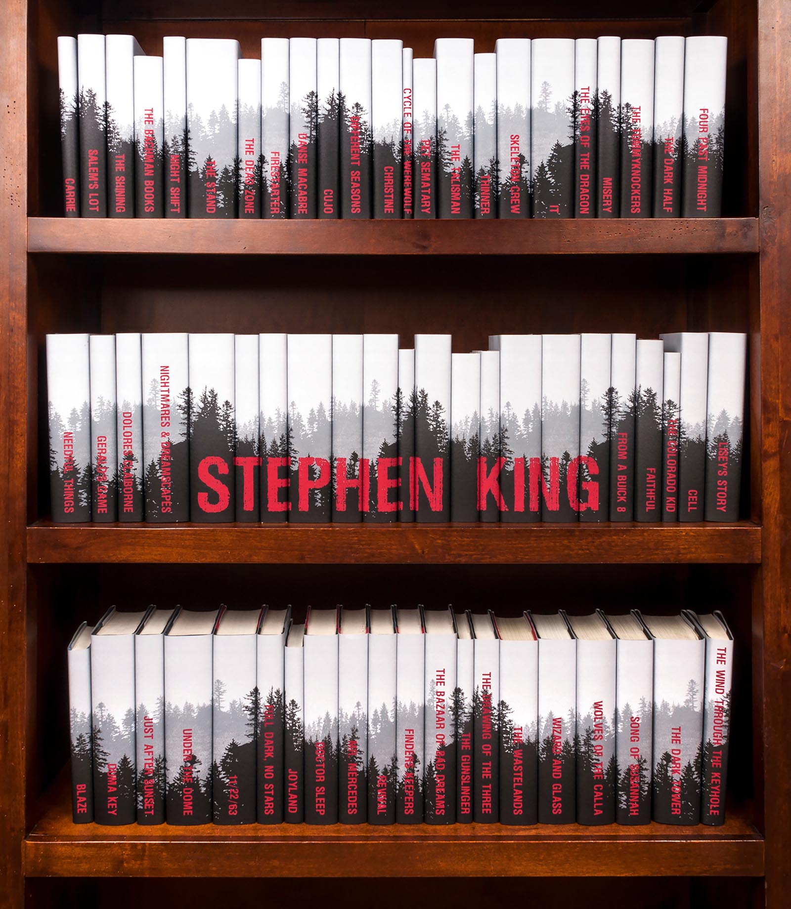 Photo of a collection of Steven King books in custom white, red, and black jackets.