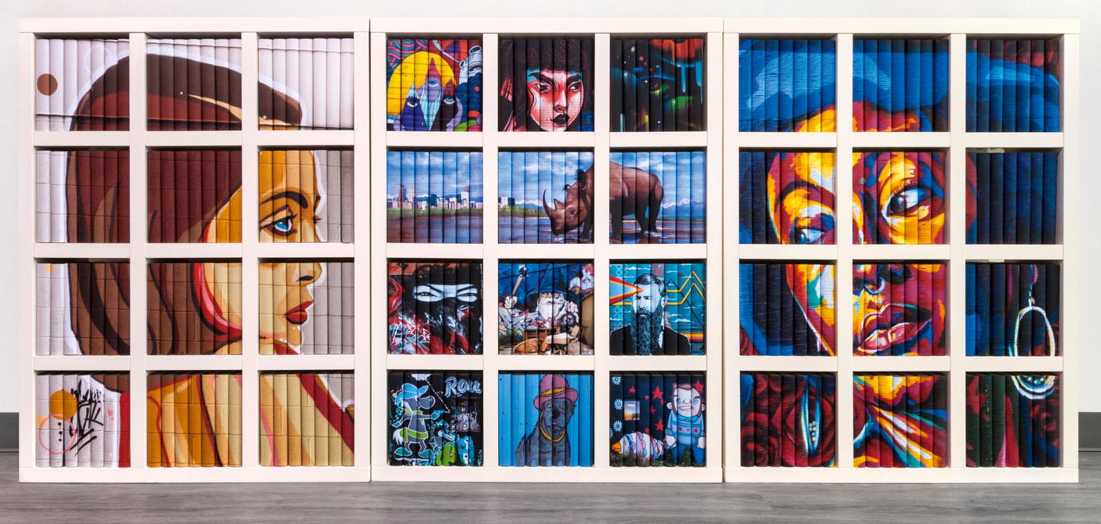 Photo of a group of large bookshelves featuring custom jackets with contemporary art showing along groups of the book spines.