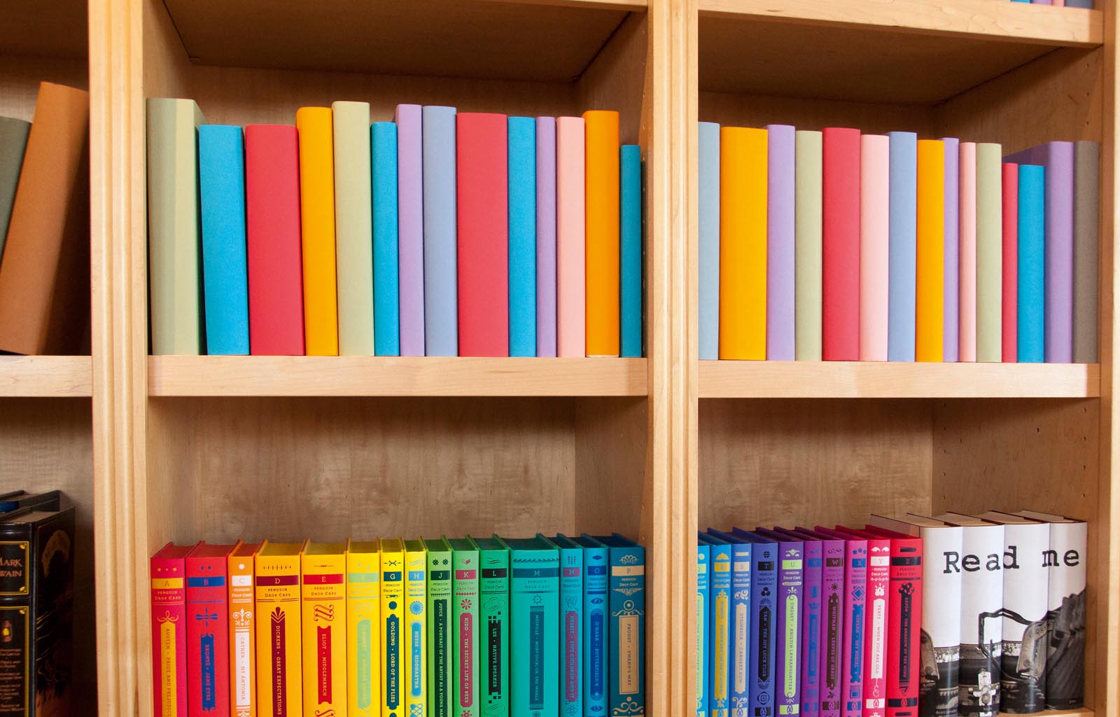 Photo of shelves of books in colored paper jackets, or colorful binding.