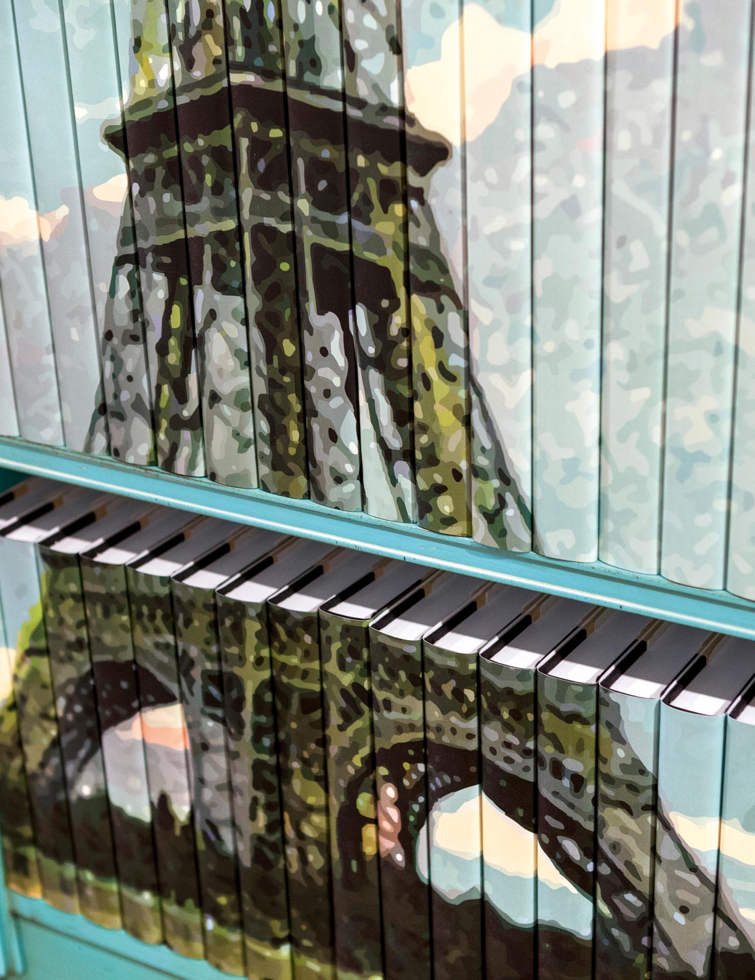 Photo of shelves of books with jackets whose spines gather to form an image of the Eiffel tower.