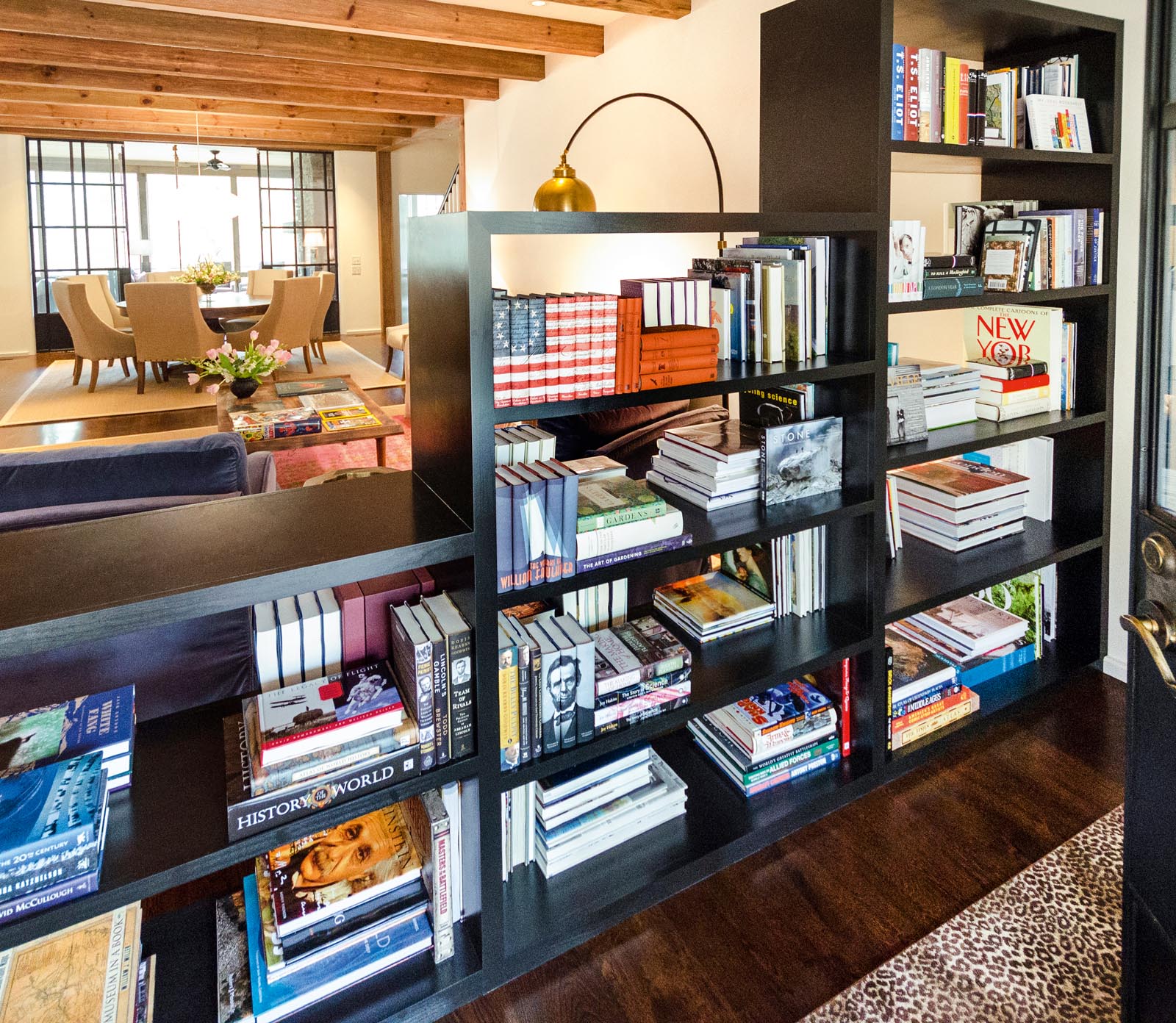 Photo of a set of shelves with graduated heights separating a sitting area from the entrance.