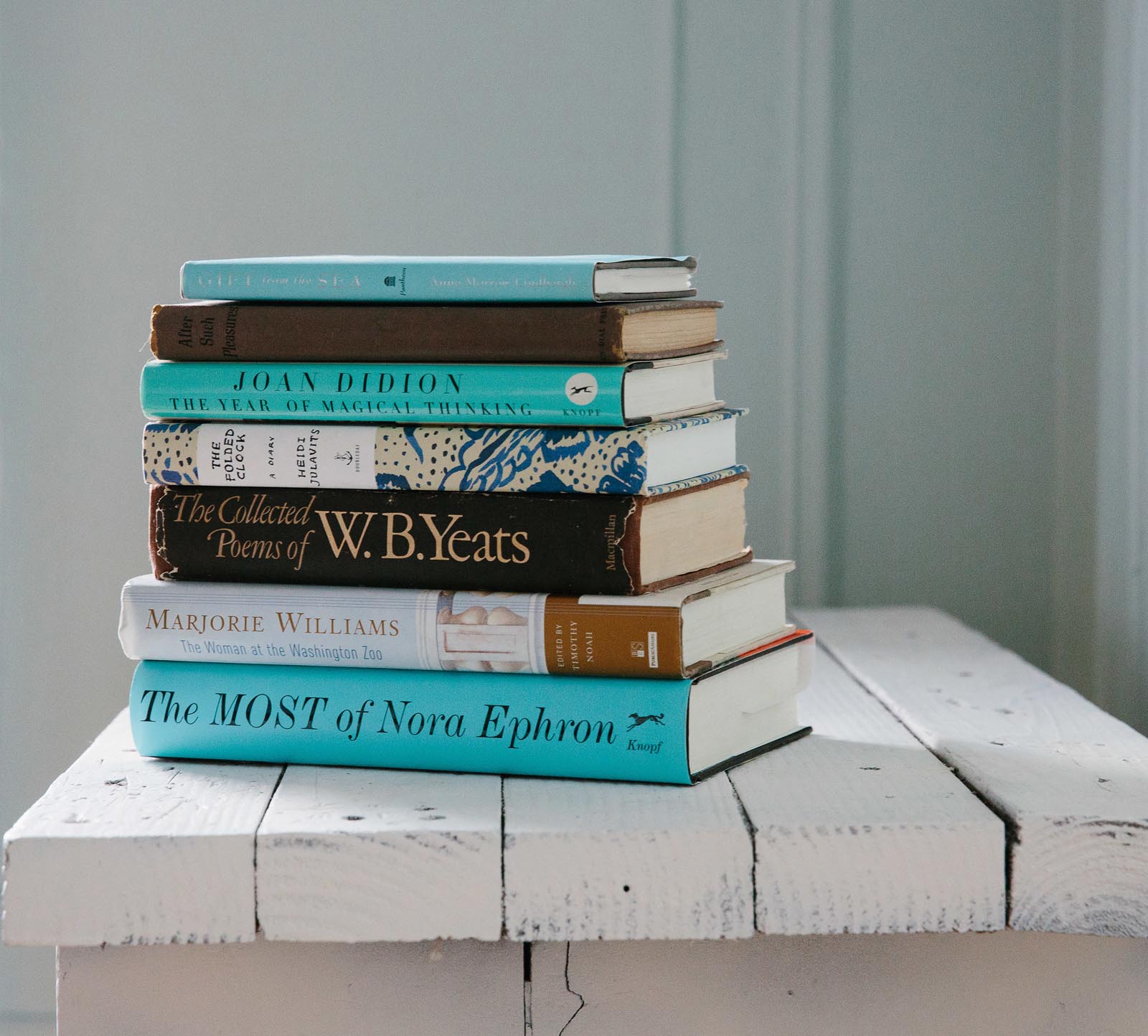 Photo of a stack of books on a rustic platform.