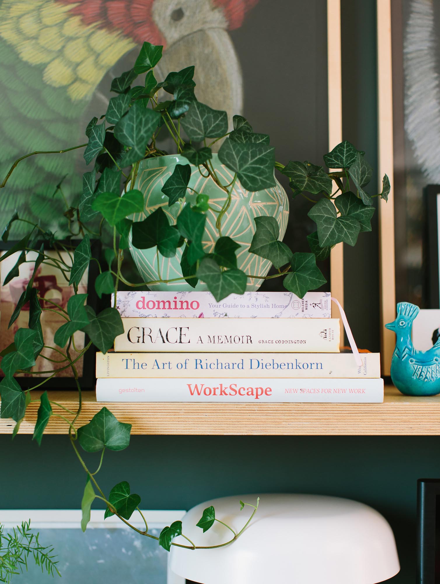 Photo of potted ivy and other decorations around a stack of books.