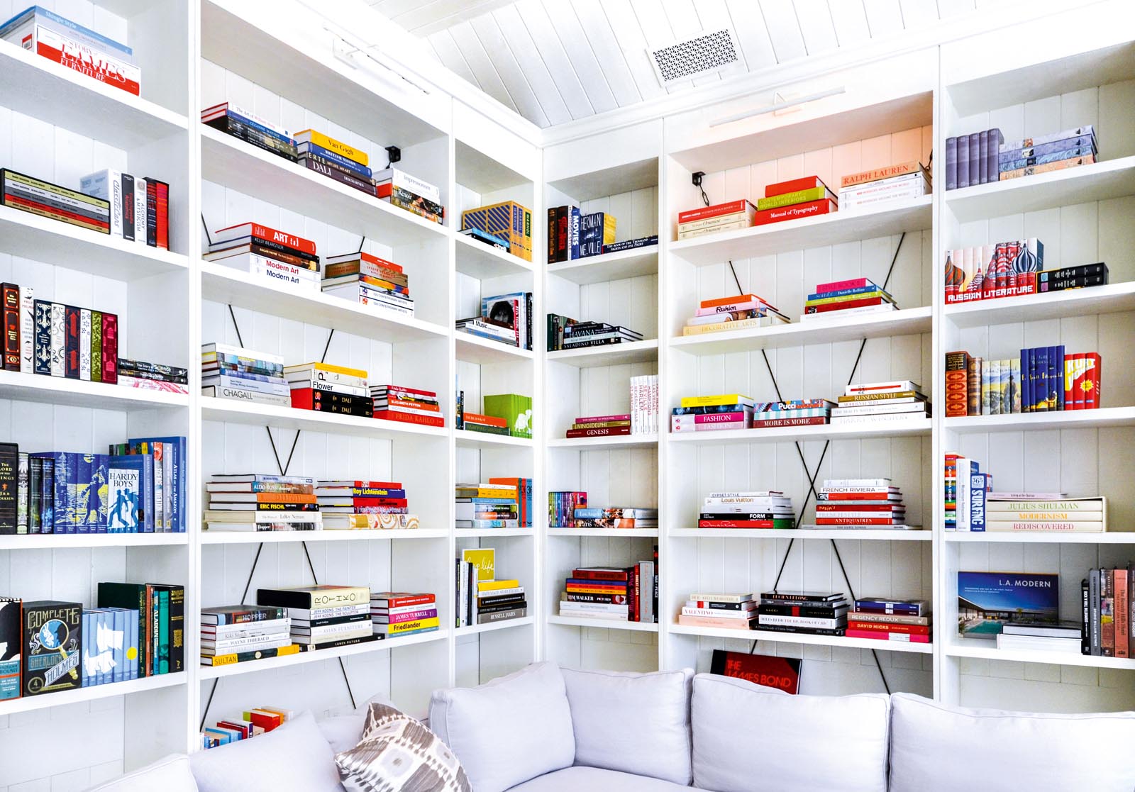 Photo of a view of the sets of white shelving behind white sofa cushions.