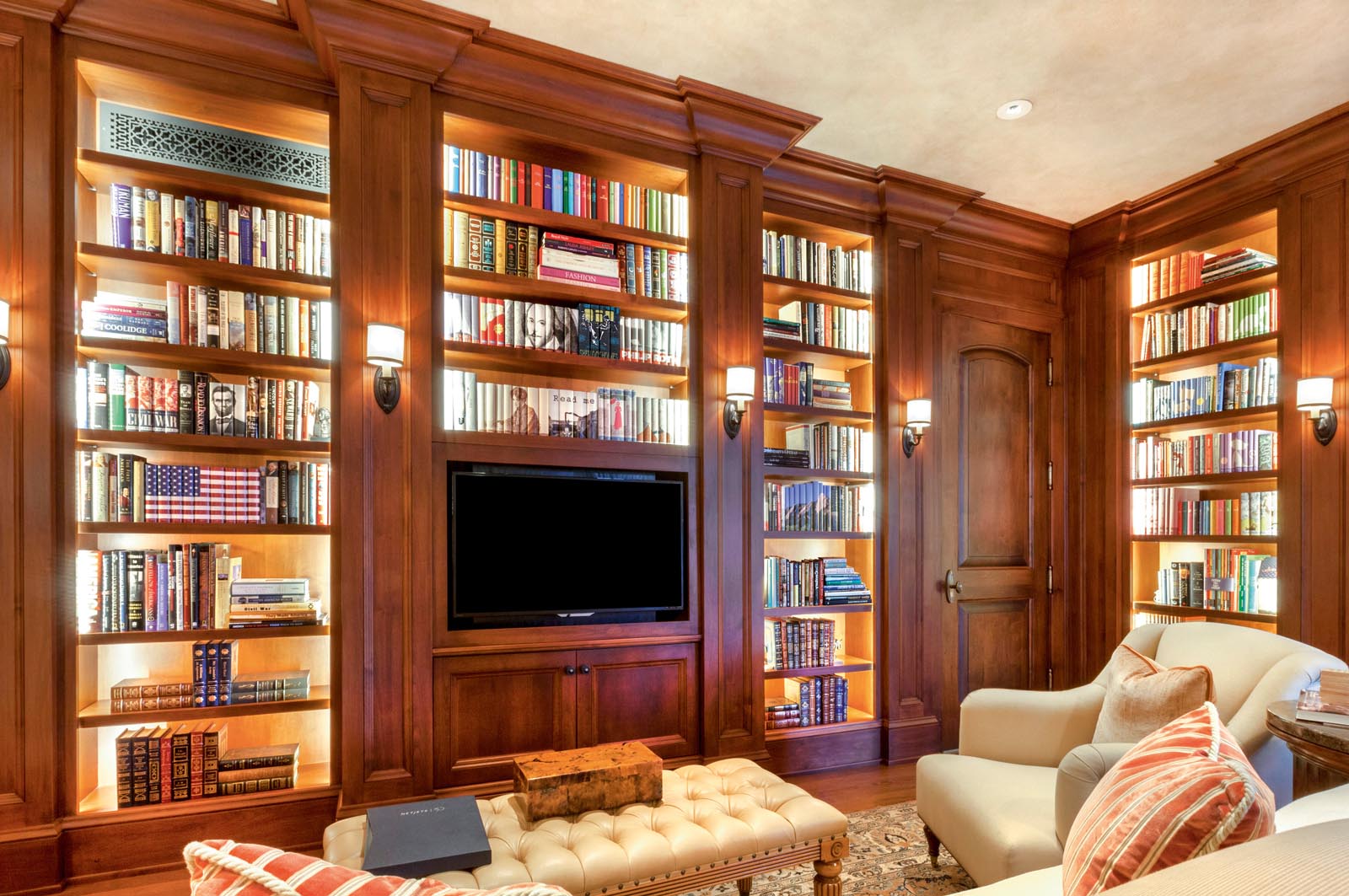 Photo of the library room with built-in shelves filled with hardcover collections.