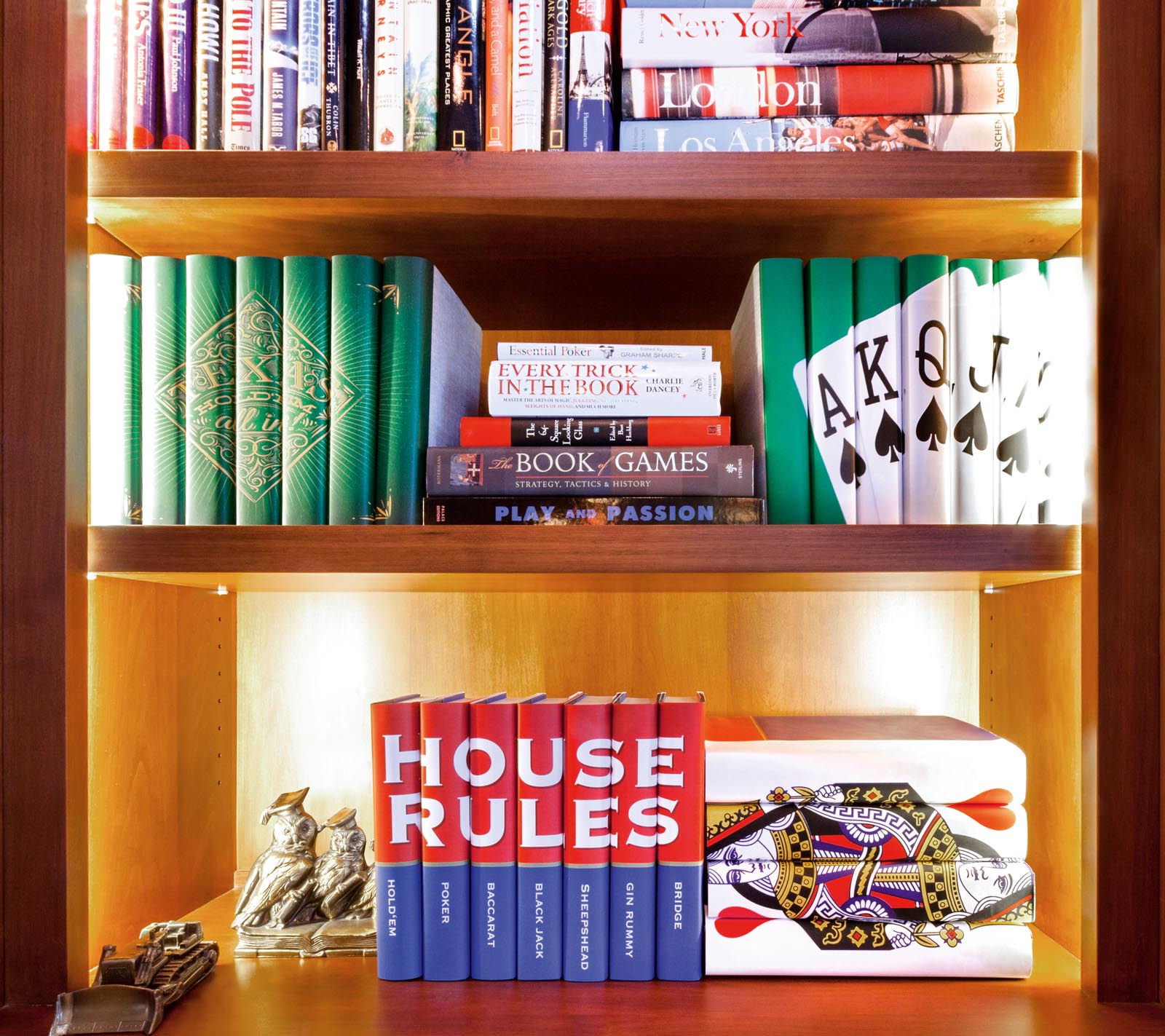 Photo of shelves of books with a theme of playing cards and games.