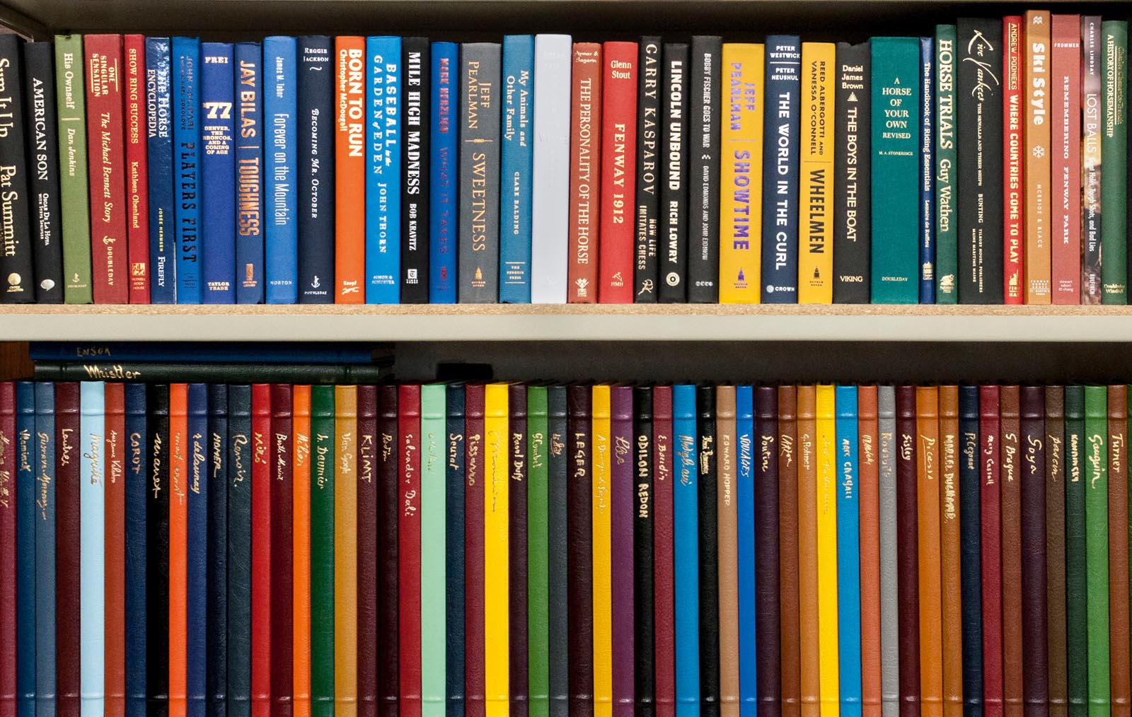 Photo of shelves of hardcovers and slim leather-bound titles.