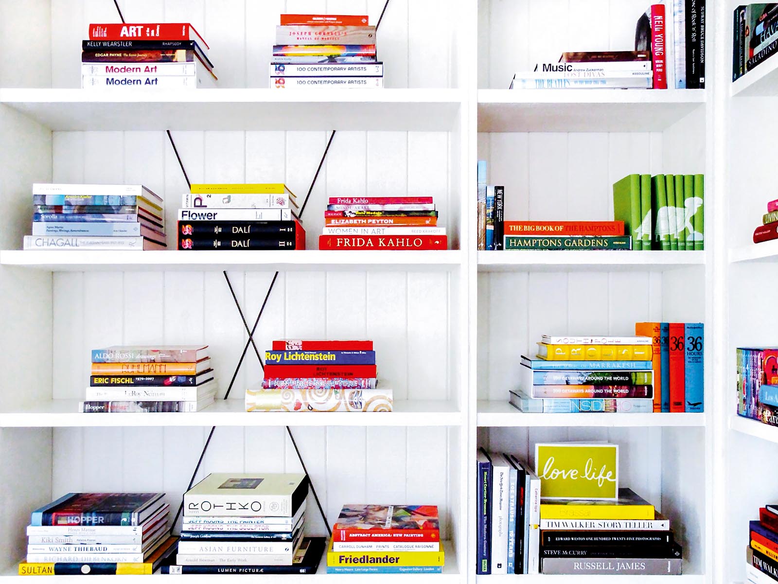 Photo of stacks of books on white-paneled open-feeling shelves.