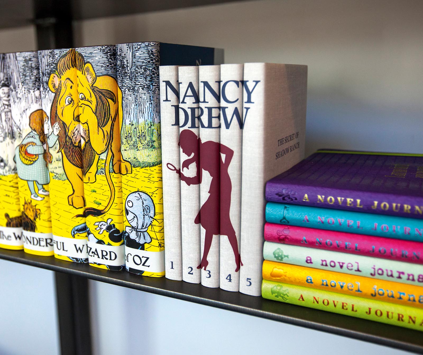 Photo of groups of books, including custom-jacketed Wizard of Oz and Nancy Drew series.