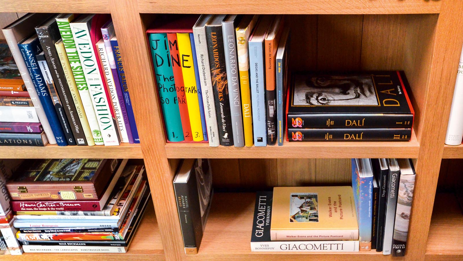 Photo of an angled view of bookshelves with collections of books.