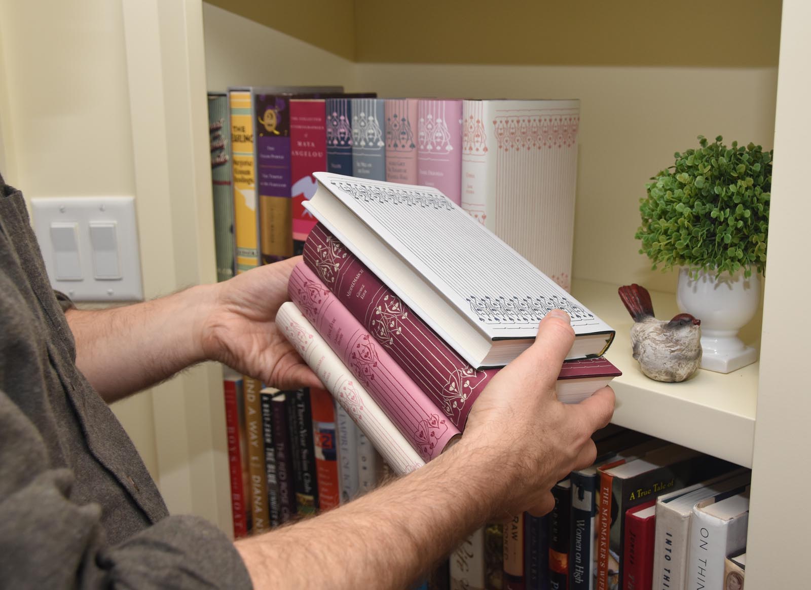 Photo of checking the appearance of a stack of books in custom jackets, one with pages out.