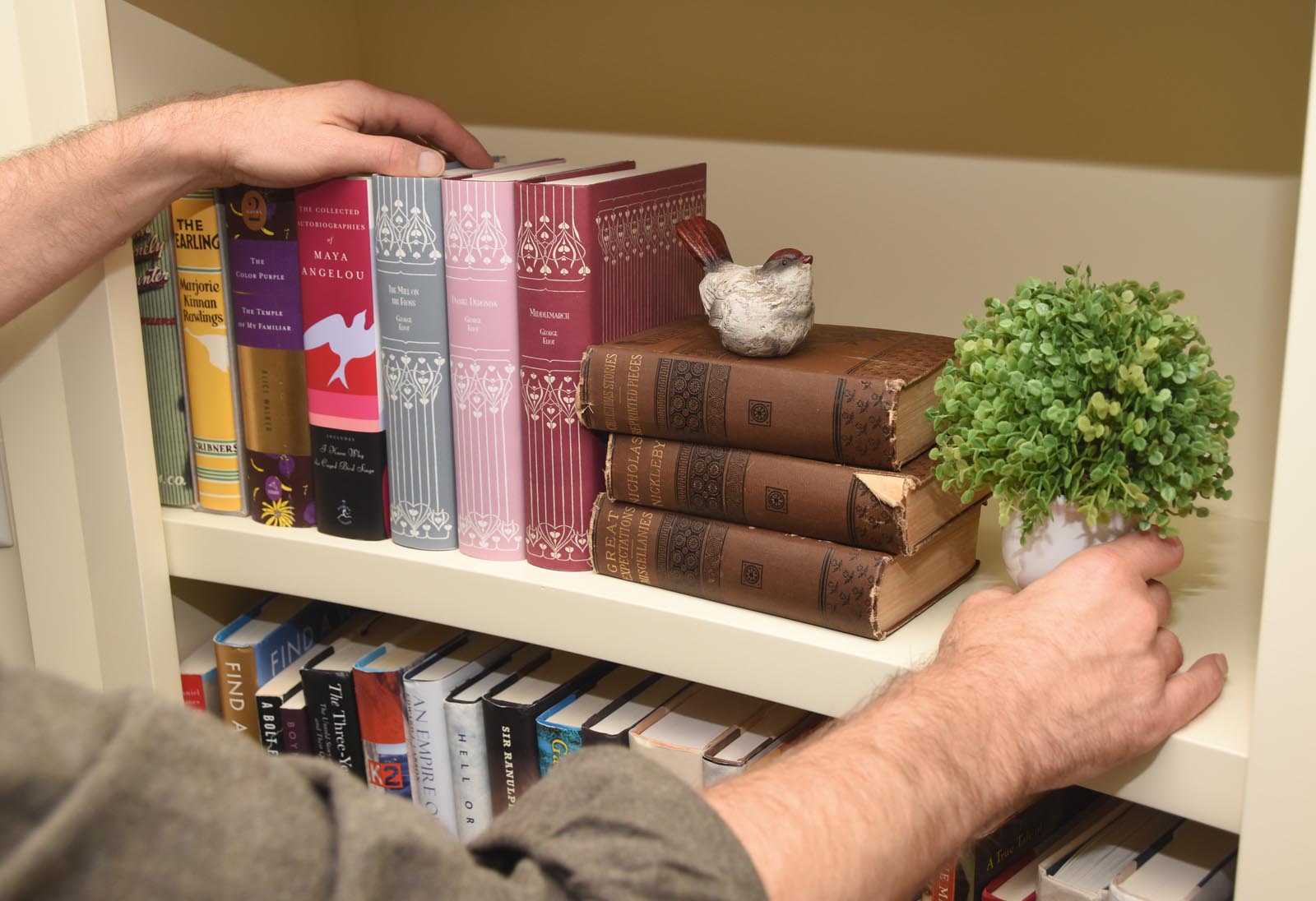 Photo of arranging decorative objects next to vertical and horizontal books.