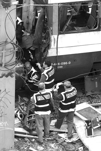 Esperti forensi spagnoli alla ricerca di indizi in un treno coinvolto negli attentati di Madrid. Gli attentati terroristici del 2004 furono tra i più cruenti che la storia spagnola ricordi. (© Pierre-Philippe Marcou/AFP/Getty Images)