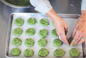 Forming balls of falafel on a parchment-lined baking sheet