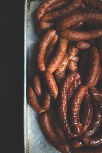 Crisp, juicy sausage piled in a metal roasting pan