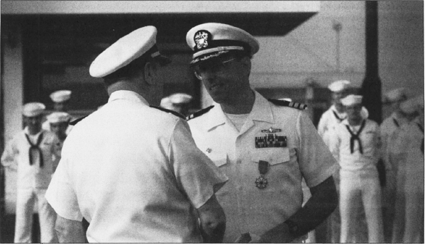 Cdr. Paul X. Rinn, captain of the Roberts, receives the Legion of Merit from Adm. William J. Crowe, chairman of the Joint Chiefs of Staff, at a pierside ceremony in Dubai on 3 May 1988.