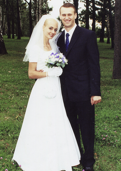 Alexej und Julija an ihrem Hochzeitstag in Anzug und Brautkleid mit Blumenstrauss im Jahr 2000.