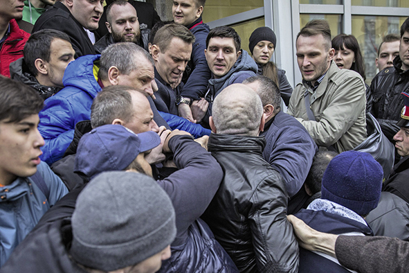 Eröffnung des Hauptquartiers in Wolgograd im Jahr 2017. Provokateure zerren Alexej nach draußen, während Anhänger versuchen, ihn wieder hineinzuziehen. 