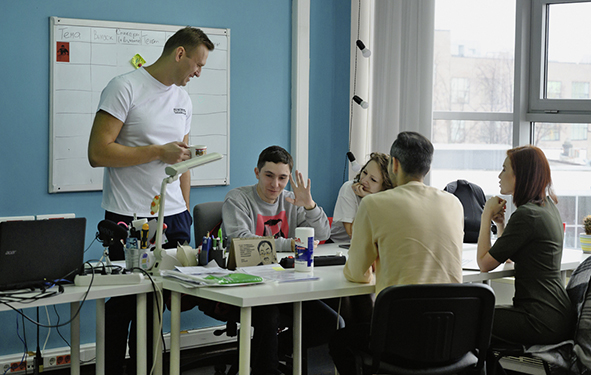 Alexej auf einer Stabssitzung im Büro der Stiftung zur Korruptionsbekämpfung 2017. Man sieht Alexej stehen, wärend sein Team um den Tisch herum sitzt.