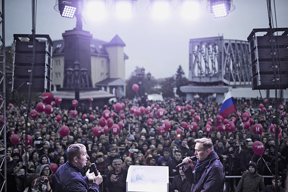 Alexej diskutiert auf einer Kundgebung in Nowosibirsk während des Präsidentschaftswahlkampfs mit einem Aktivisten der Partei Einiges Russland 2017. Man sieht beide Diskutanten im Vordergrund vor eine großen Menschenmenge. 