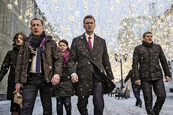 Alexej und seine Kollegen 2017 auf dem Weg zur zentralen Wahlkommission, es schneit, und im Hintergrund ist Weihnachtsdekoration von Geschäften zu sehen.