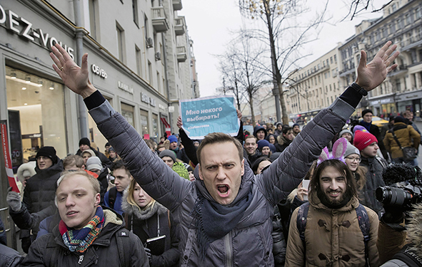 Alexej 2018 bei der Kundgebung zum Wählerstreik. Man sieht ihn von vorne, beide Arme nach oben gestreckt. 