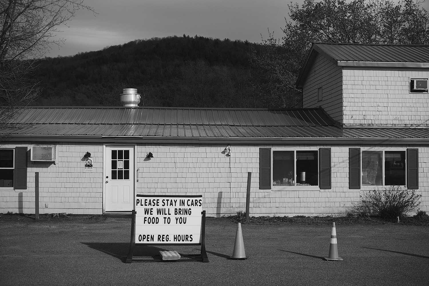 Restaurant sign: Please stay in cars. We will bring food to you.