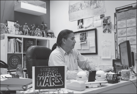 Manuelito Wheeler, Director of the Navajo Nation Museum, with a scale model of the truck-mounted screen he used to show the first movie in the Navajo language: a little something called Star Wars, to which his office is a shrine.