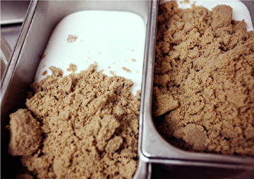 Brown sugar and confectioners’ sugar in a metal container