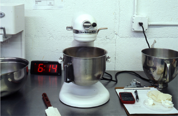 Stand mixer next to a clipboard and an alarm clock