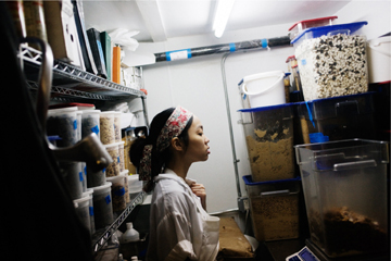 Staff looking at a large container of crumbs in storage