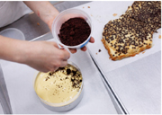 Sprinkling the chocolate crumbs over the fruit curd layer