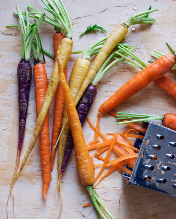 Carrots of various colors near a grater