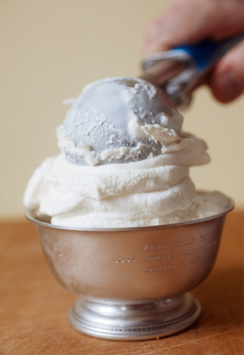 Placing a scoop of Cheesecake Ice Cream into a metal dish