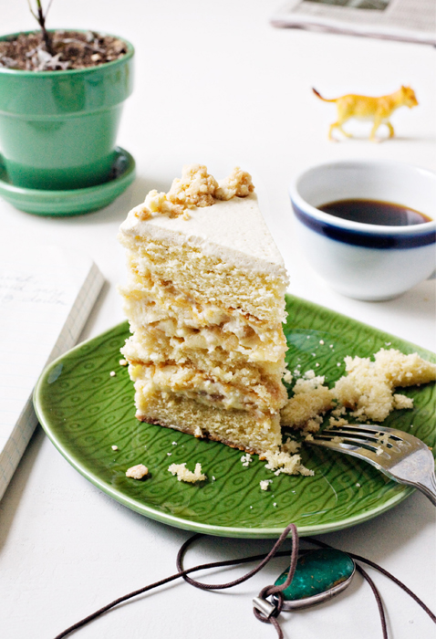 A slice of Apple Pie Layer Cake on a green plate with a fork