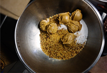 Balls of peanut butter and ground-up brittle in a metal bowl