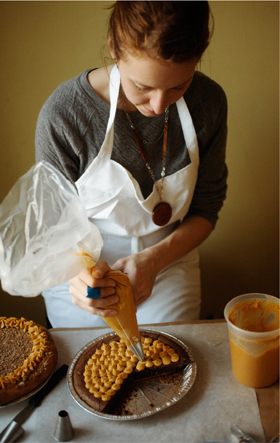 Christina Tosi piping pumpkin ganache onto a pie