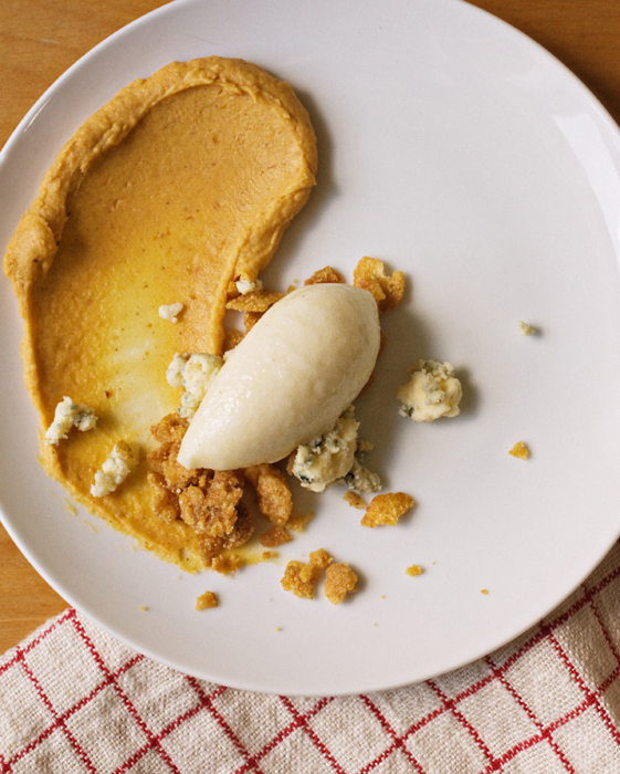 Overhead shot, a white plate with Pear Sorbet Stilton, Cornflake Crunch, Pumpkin Ganache